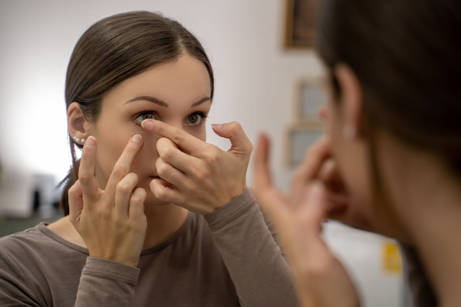 Woman fitting a soft contact lens