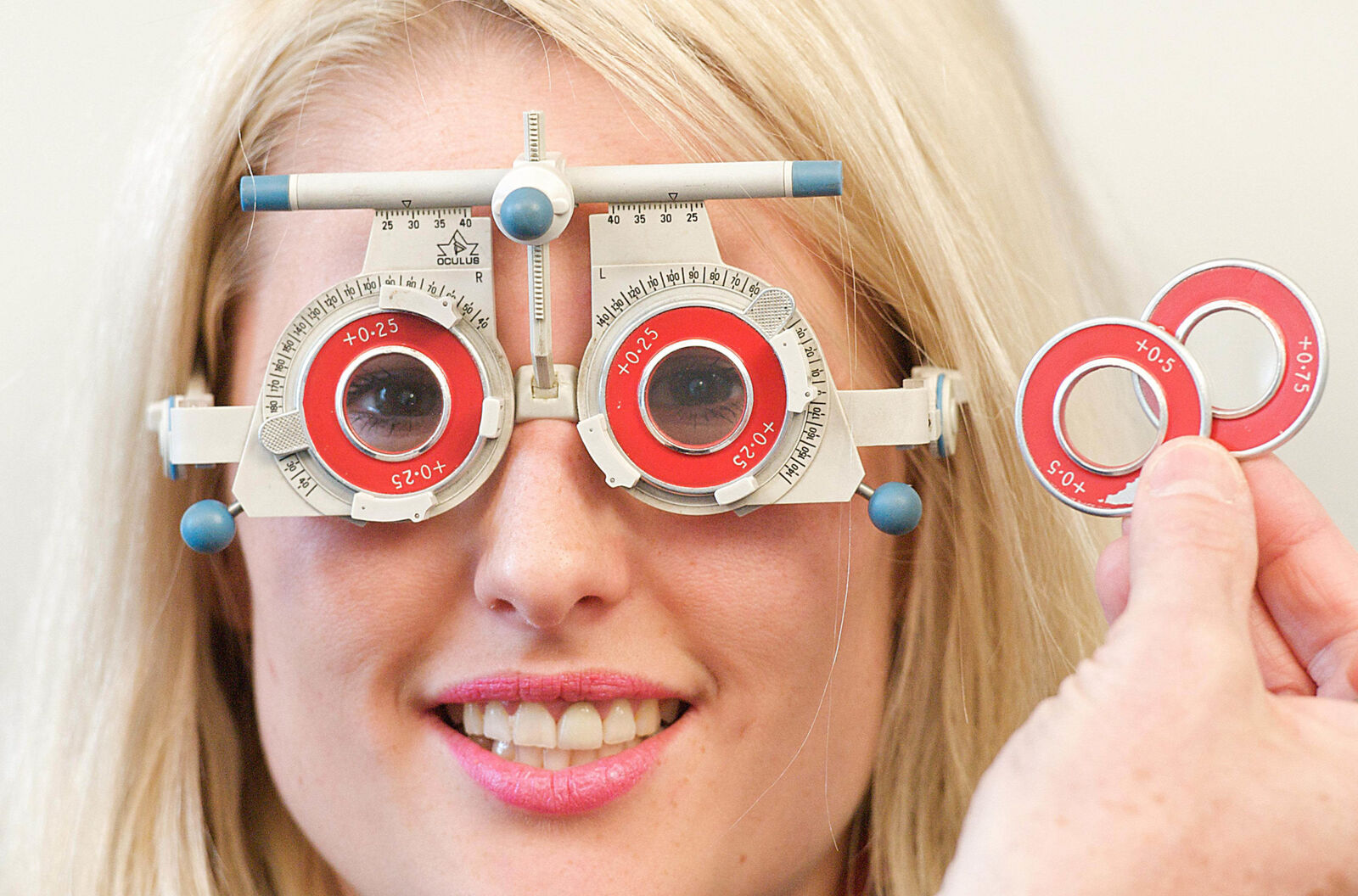 Smiling patient wearing a trial frame during an eye test
