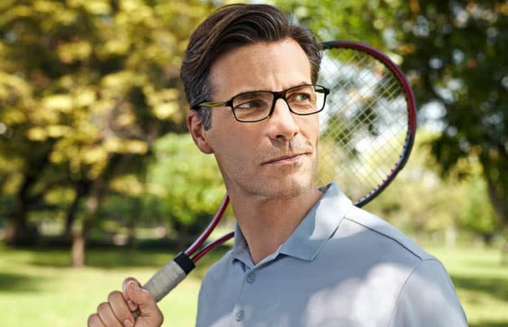 Man playing tennis wearing Varilux varifocal lenses